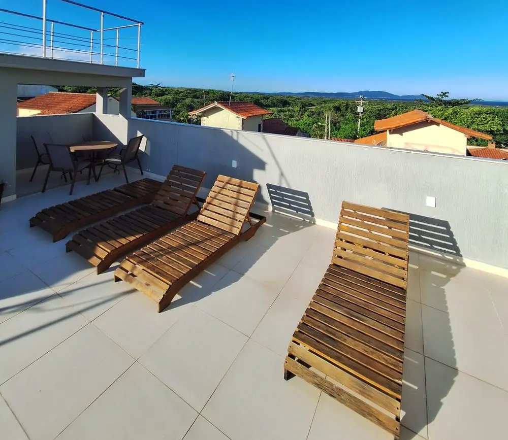 Terraço com espreguiçadeiras de madeira e vista para a região