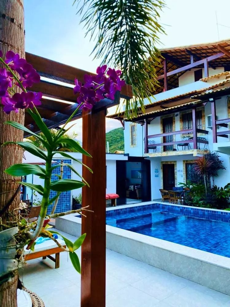 Detalhe do jardim com orquídeas e piscina ao fundo