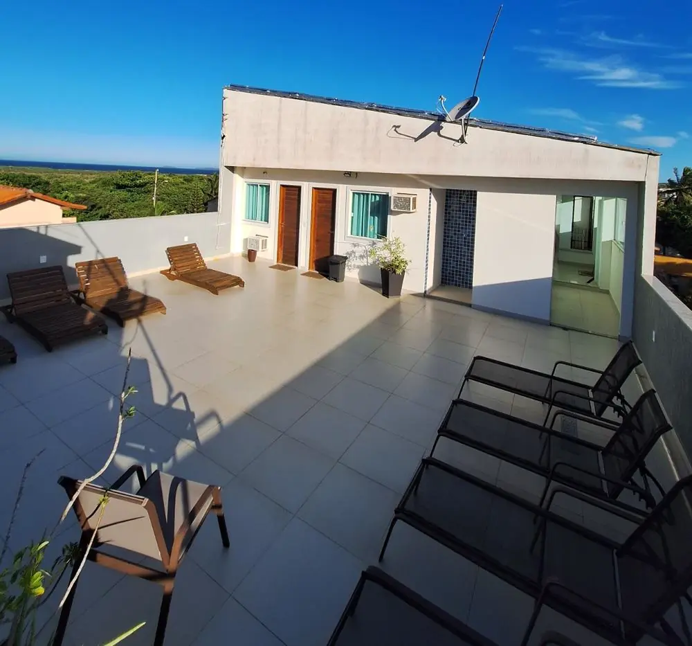 Terraço da pousada com espreguiçadeiras e vista